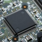 Closeup of electronic circuit board with CPU microchip electronic components background